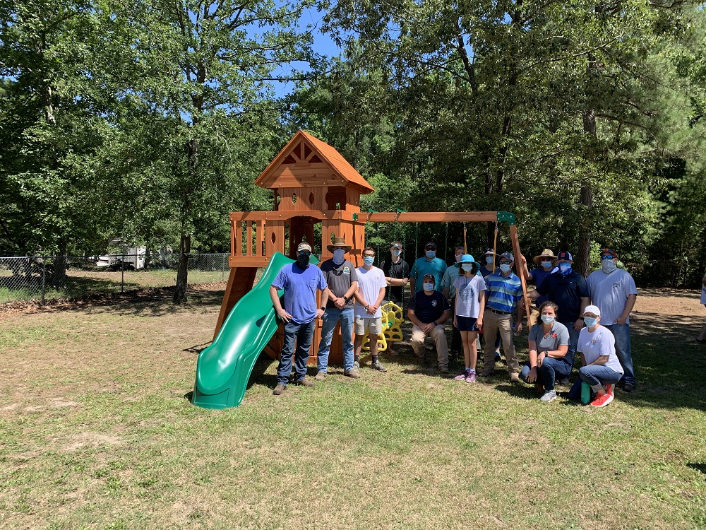 Barnhill employees Stand by a playset