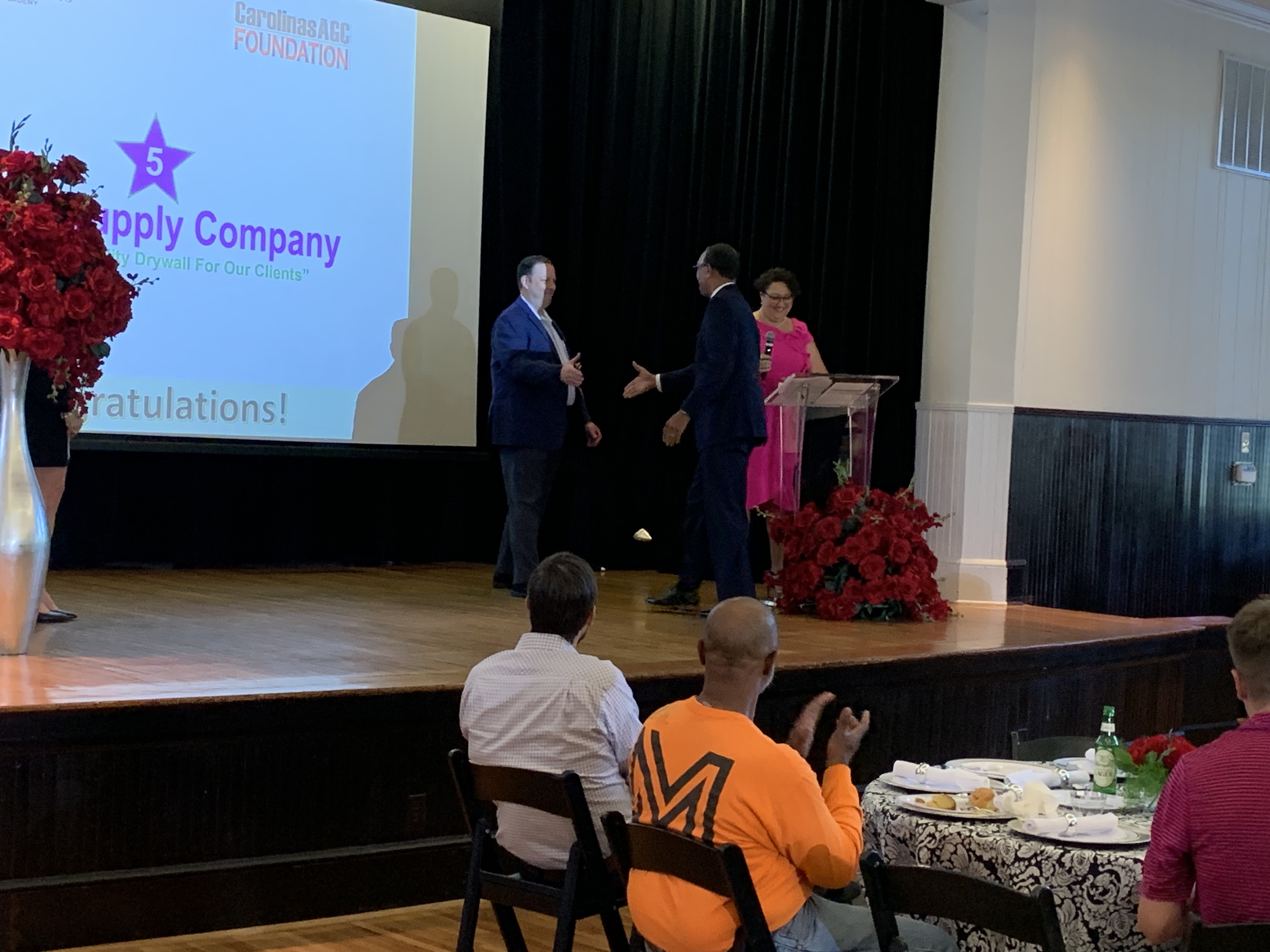 Graduate shakes hands with professor before receiving certificate